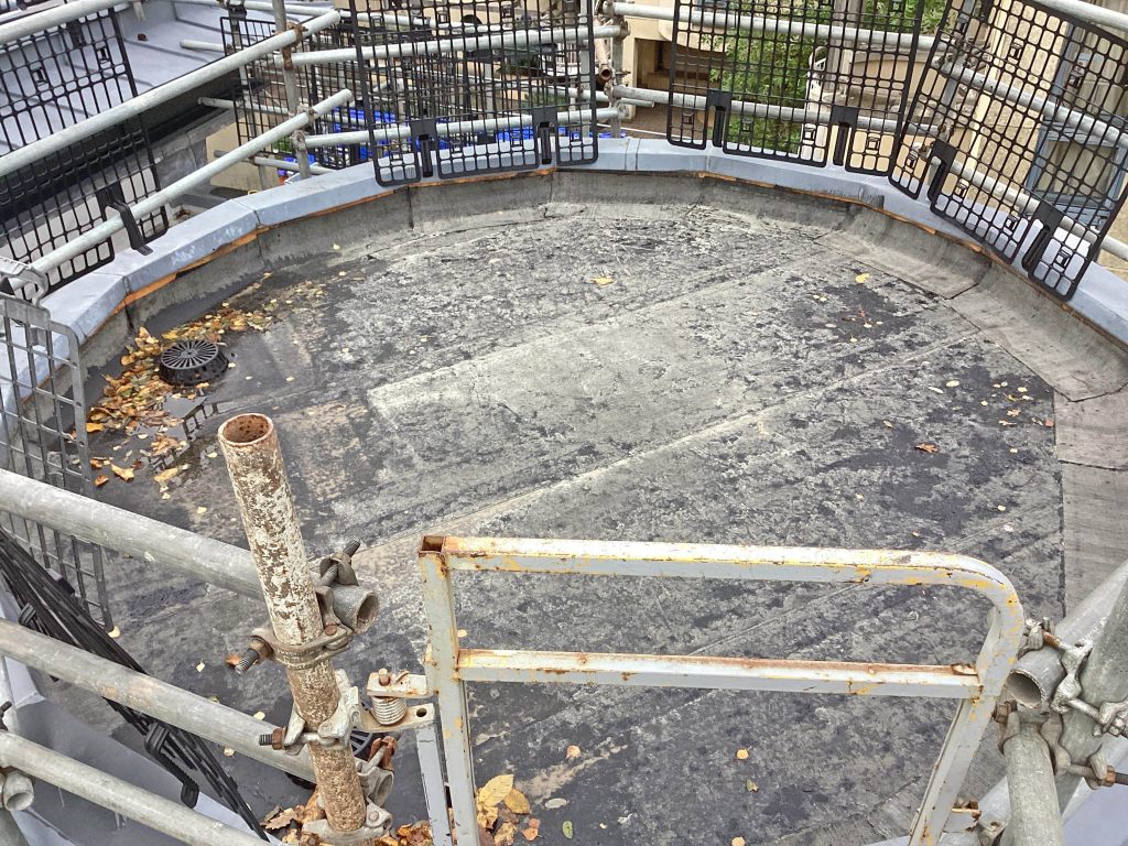 Circular flat roof before Central Group refurbishment, with visible wear and old waterproofing system.